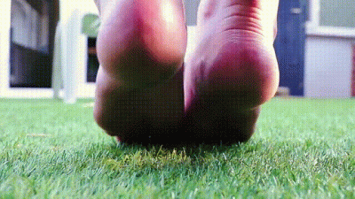 Barefoot Goddess Rubs Her Feet On Grass In The Summertime