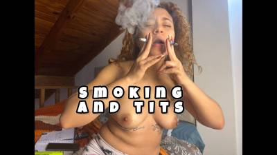 Smoking With Her Breasts Exposed