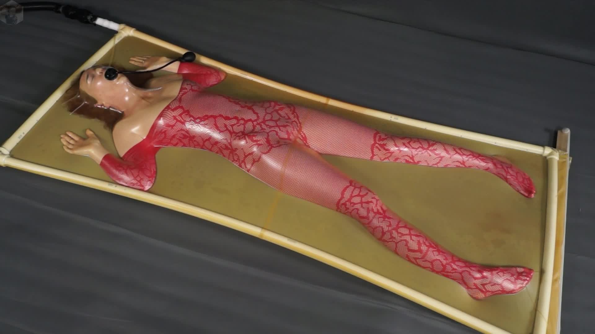 Red Costume And Pear Gag In A Latex Bed