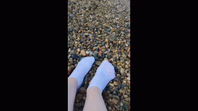 Playing With My Feet In White Socks With Pebbles On The Beach